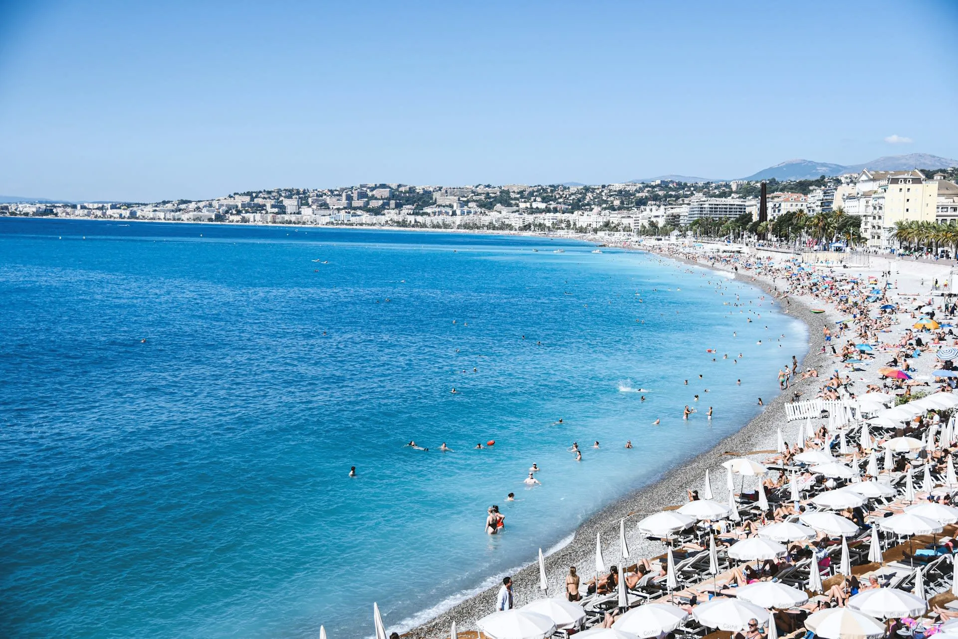 Baie des Anges in Nice met parasols en zwemmers langs het kiezelstrand