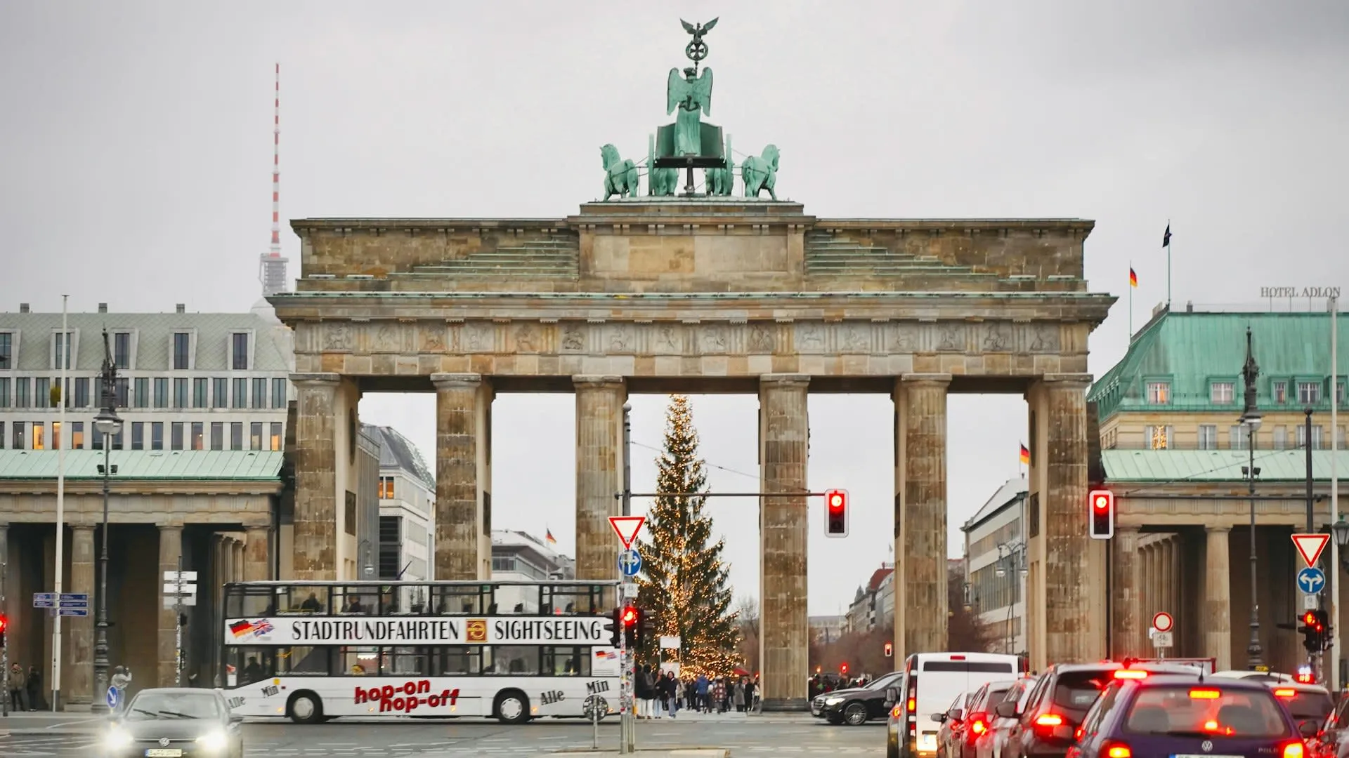 Brandenburger Tor in Berlijn in de winter met kerstboom en sightseeingbus