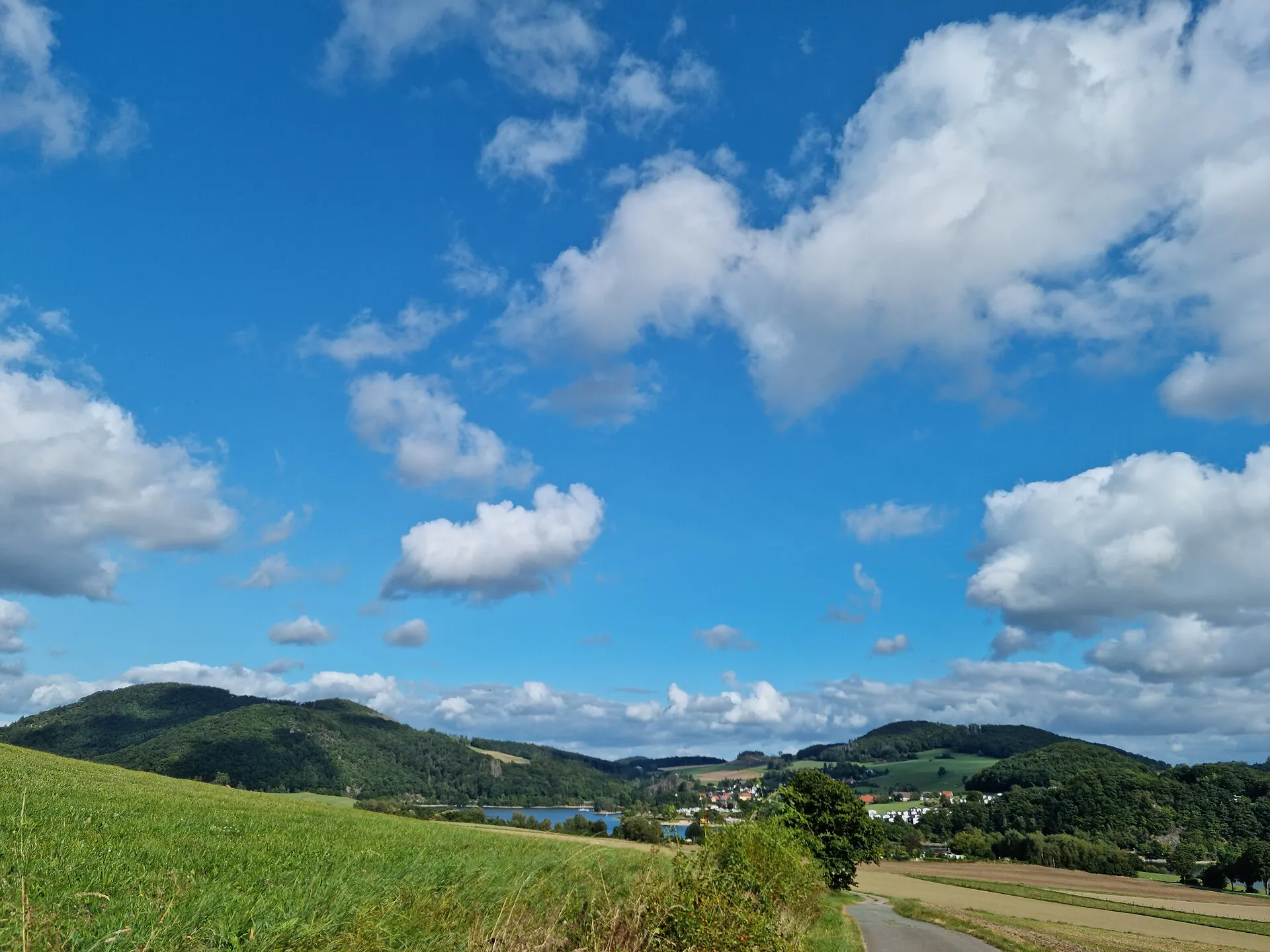 Groene heuvels rond de Diemelsee bij Heringhausen onder witte wolken in het Sauerland