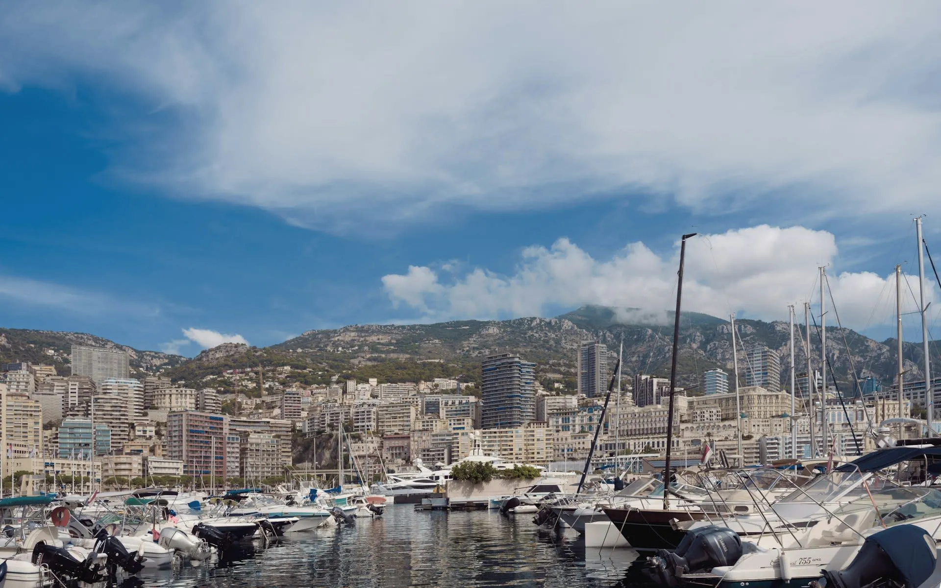 Jachthaven van Monaco met afgemeerde boten en bergen op de achtergrond