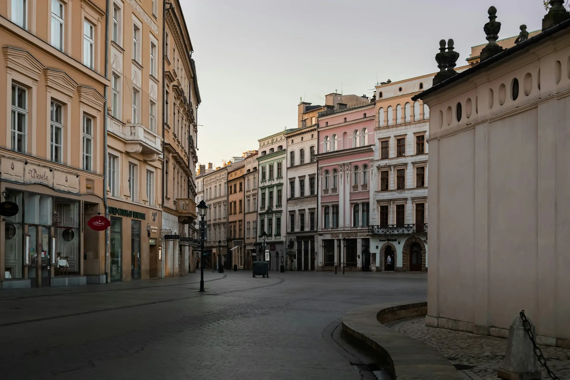 Rustige geplaveide straat in de oude binnenstad van Krakau bij zonsopgang met kleurrijke herenhuizen