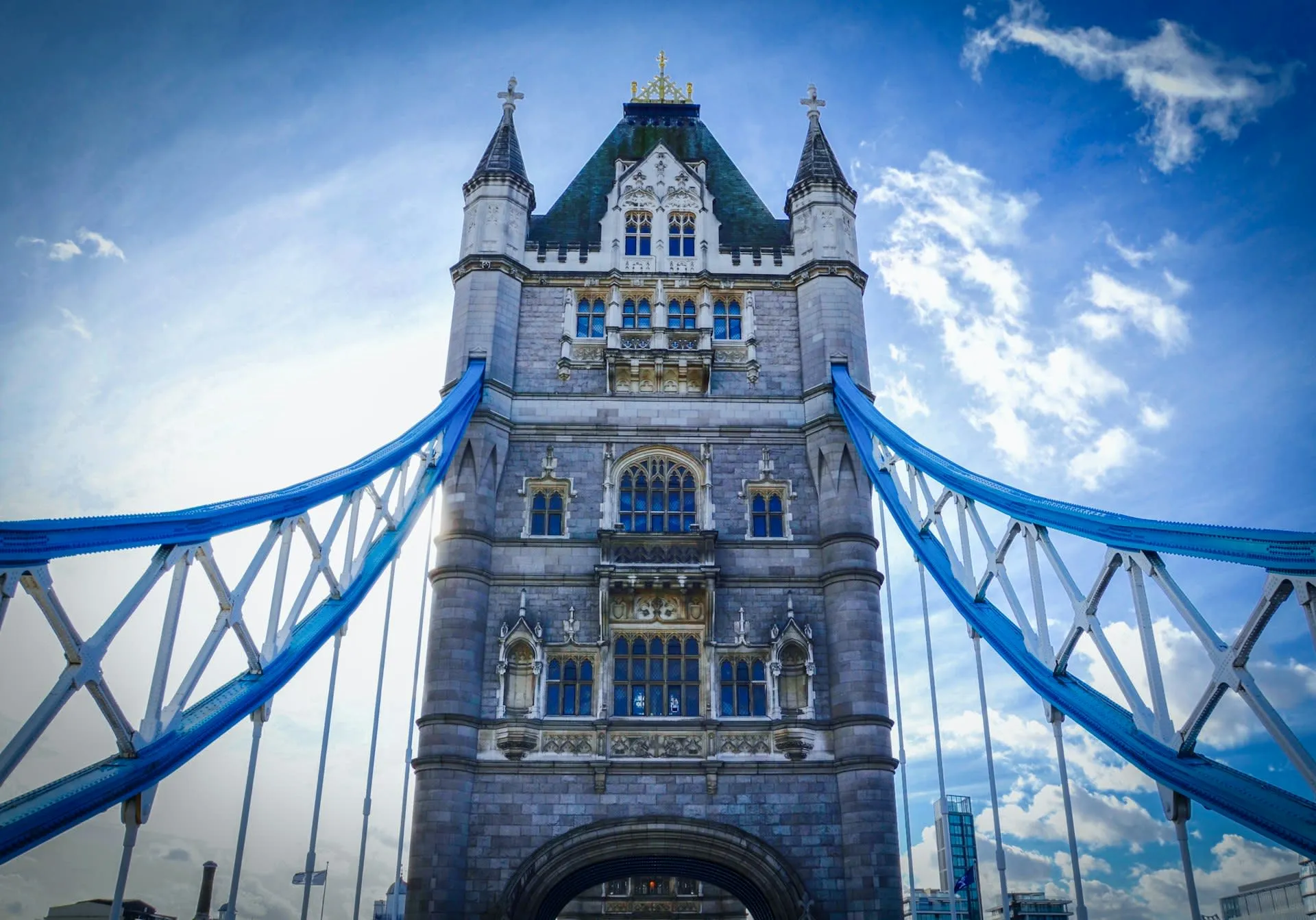 Toren van Tower Bridge met blauwe hangkabels tegen een blauwe lucht in Londen