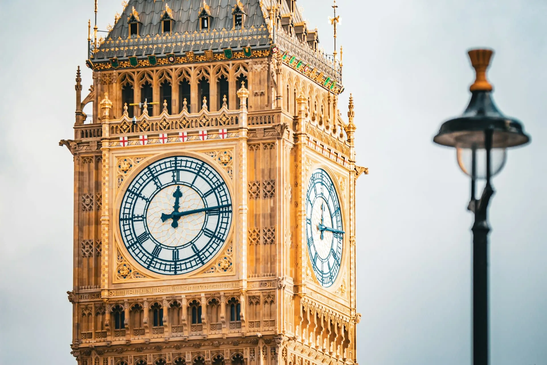 Close-up van de wijzerplaat van Big Ben met een straatlantaarn op de voorgrond in Londen