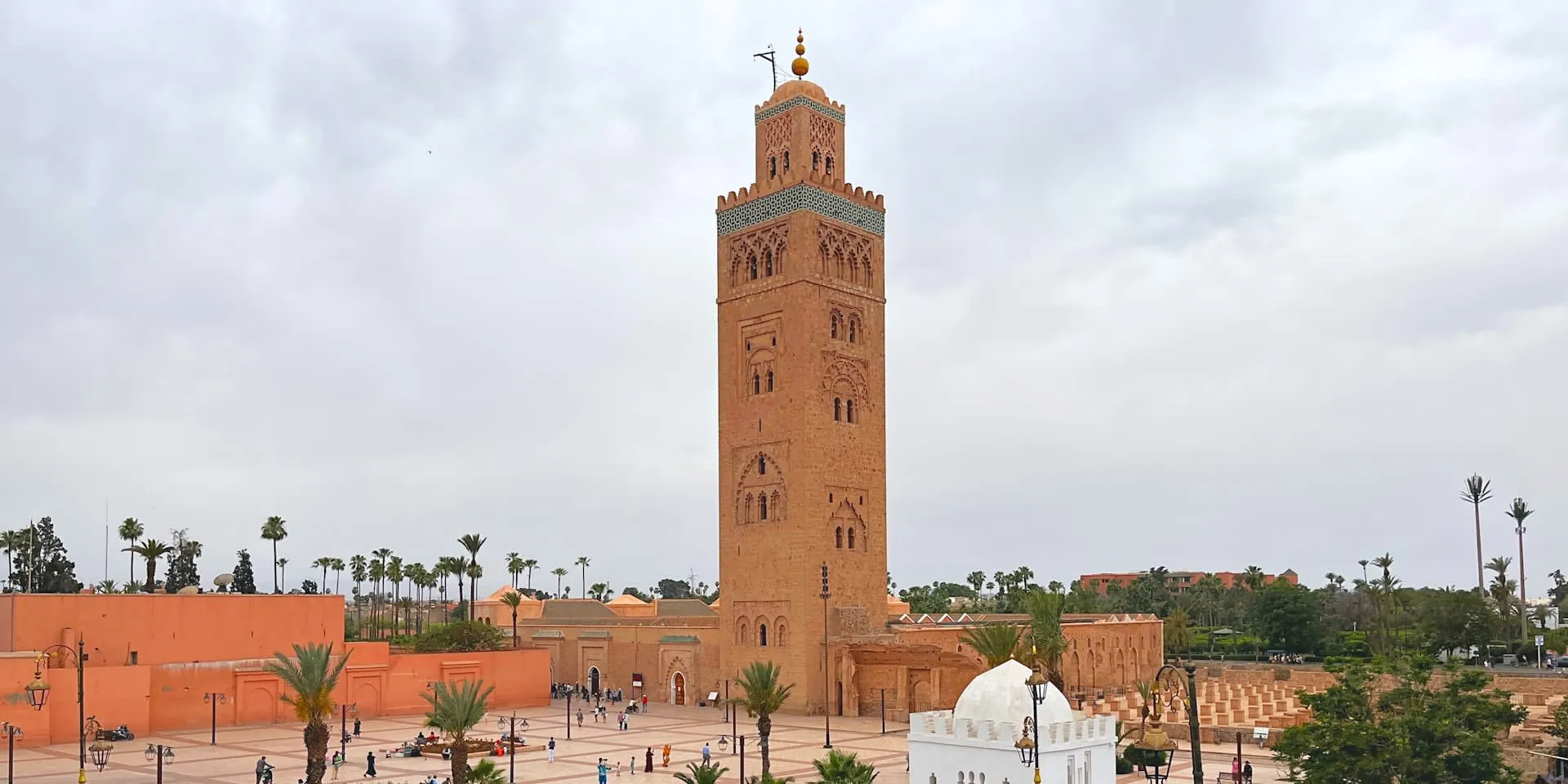 Koutoubia-moskee met hoge minaret en palmbomen aan een plein in Marrakech