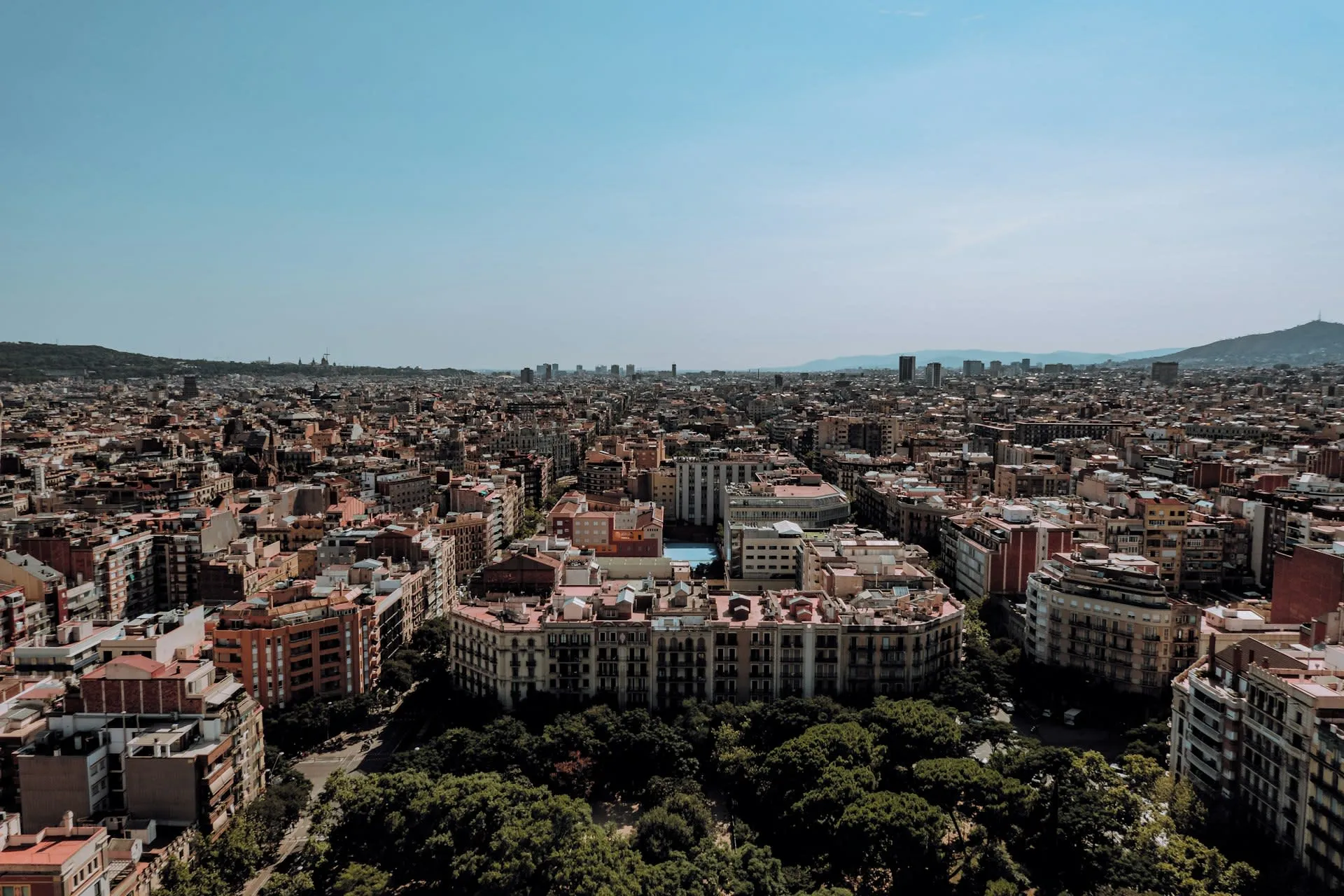 Uitzicht over de daken en straten van Barcelona onder blauwe lucht