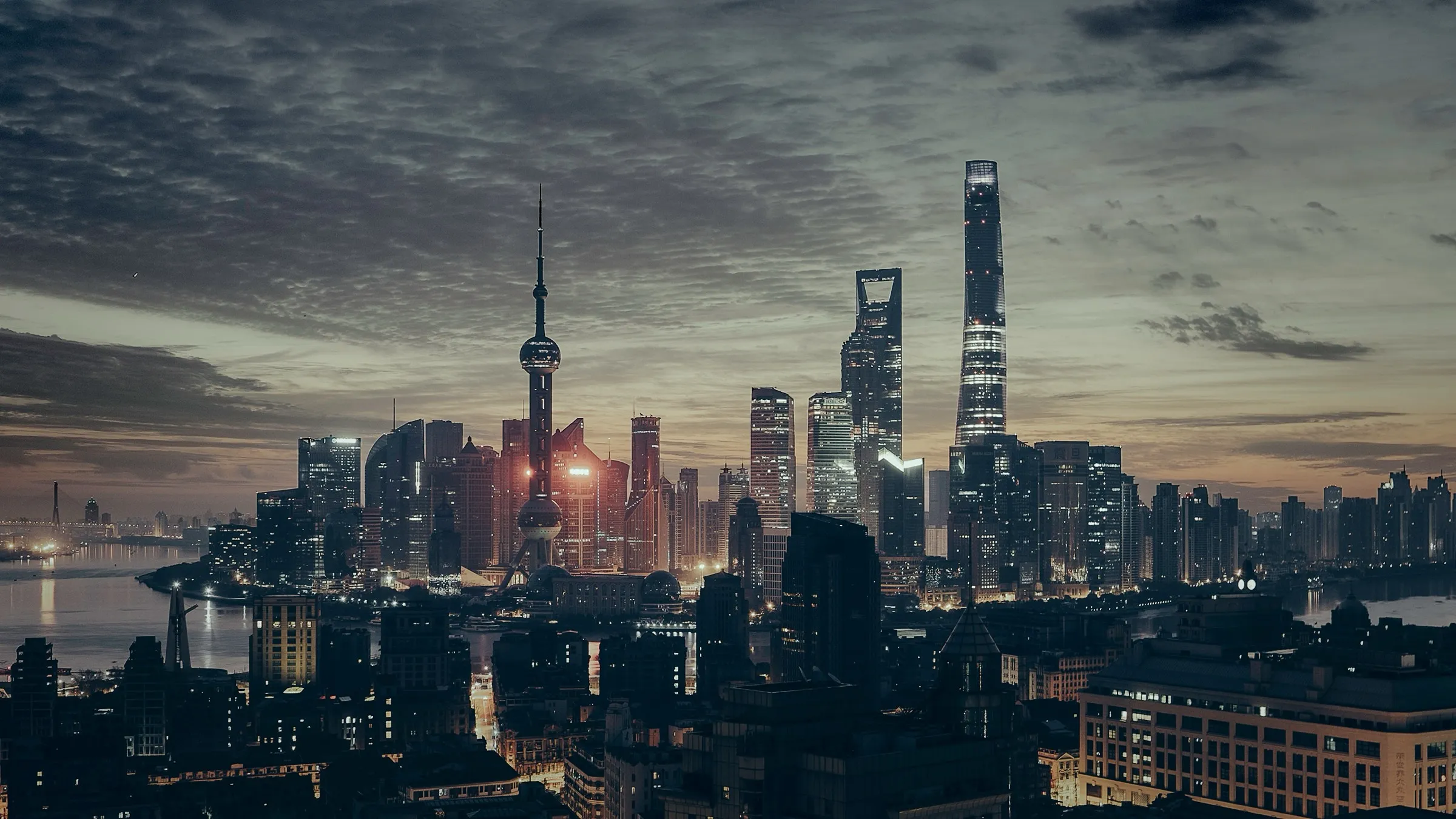 Skyline van Shanghai in de avondschemering met de Oriental Pearl Tower